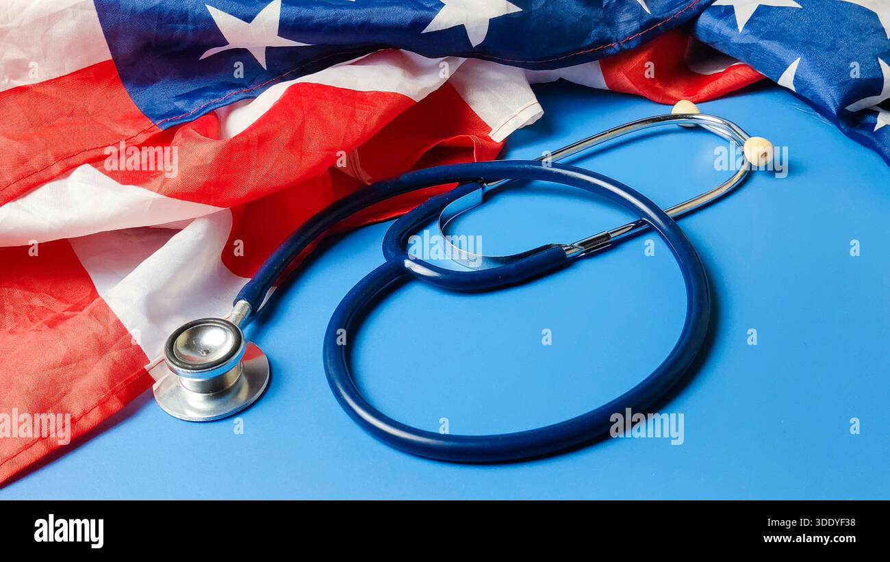 Blaues medizinisches Stethoskop, das neben einer amerikanischen Flagge steht, die die Reform des Gesundheitssystems der Vereinigten Staaten von Amerika repräsentiert, medizinische Politik und öffentlicher Gesundheitsdienst Stockfoto