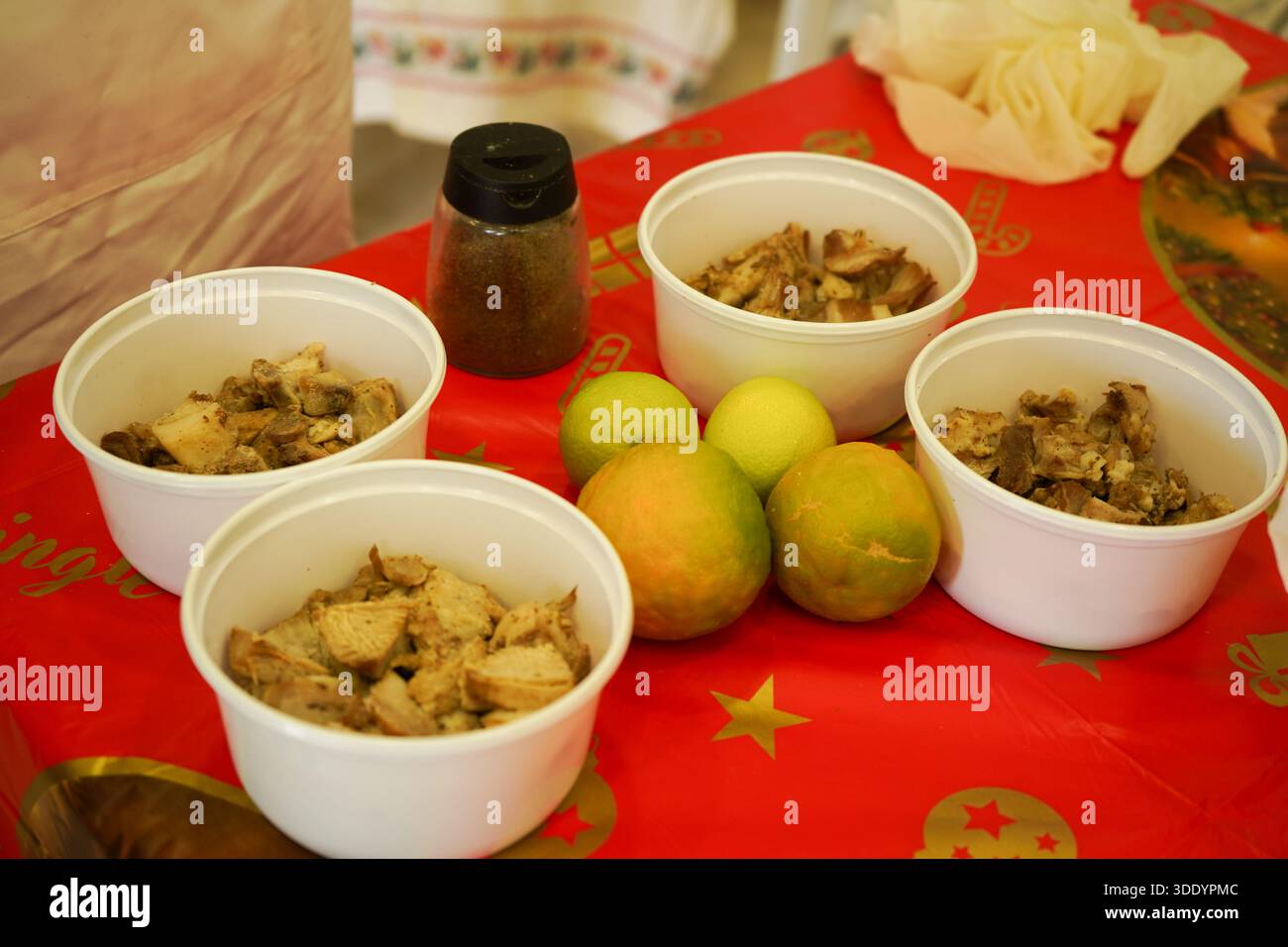 Weiße Schüsseln gefüllt mit traditionellem Schweinefleisch „Tsiladia“, serviert mit ganzen Zitrusfrüchten und Kümmel. Authentisches kretisches Winterrezept. Stockfoto