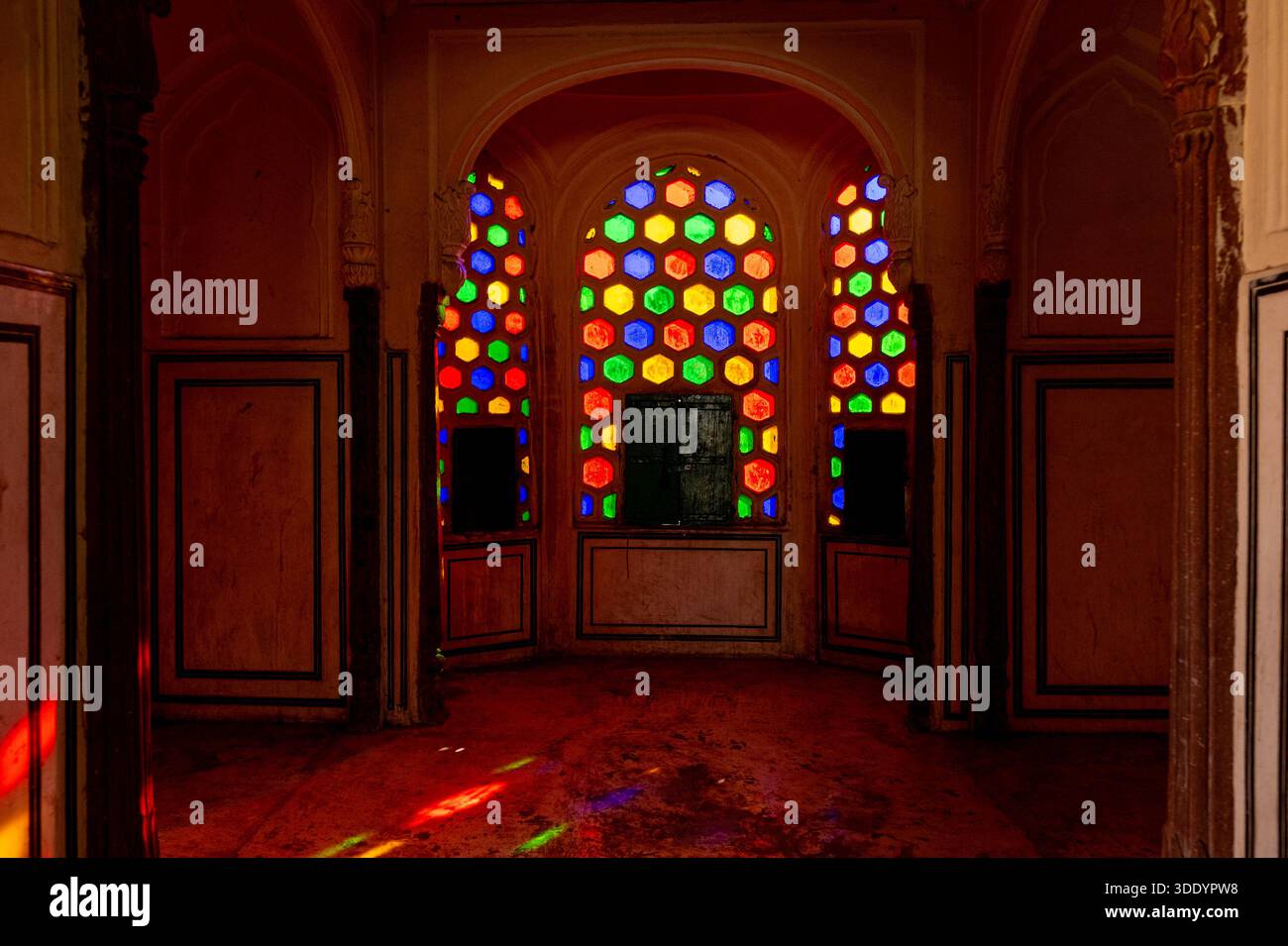 Kleine Fenster mit bunt getöntem Glas des Hawa Mahal in Jaipur, von innen gesehen, ohne Leute. Stockfoto