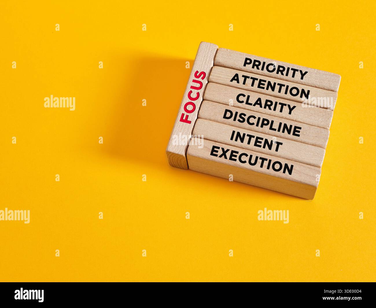 Fokussierung oder Aufbau des FOCUS-Konzepts. Holzblöcke, die den Wortschatz mit seinen grundlegenden Konzepten wie Priorität, Aufmerksamkeit, Klarheit, Disziplin, Stockfoto