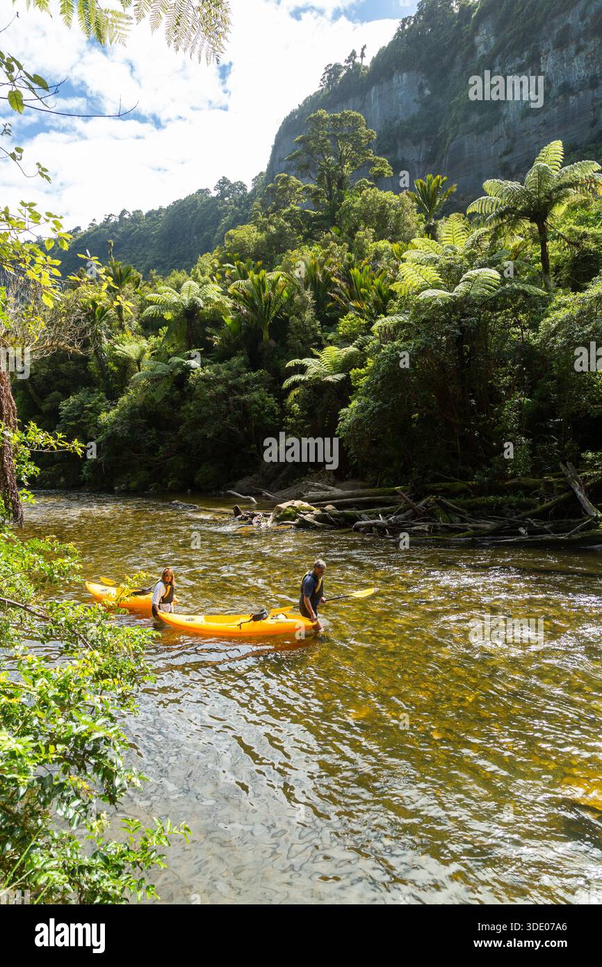 Menschen wandern Kanus im flachen Wasser auf dem Pororari River, Punakaiki, Südinsel, Neuseeland Stockfoto
