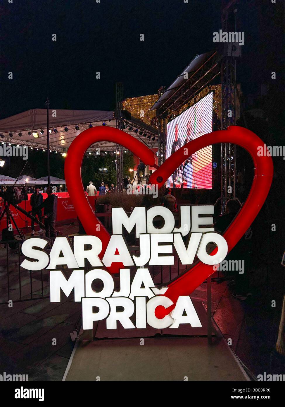 Die Installation des Sarajevo Film Festival Logos wurde während des Festivals am 22. August 2025 in Sarajevo gezeigt. Nächtliche Veranstaltungsszene mit Bühne, Bildschirm und Besucher - Smartphone-aufgenommenes Stockfoto