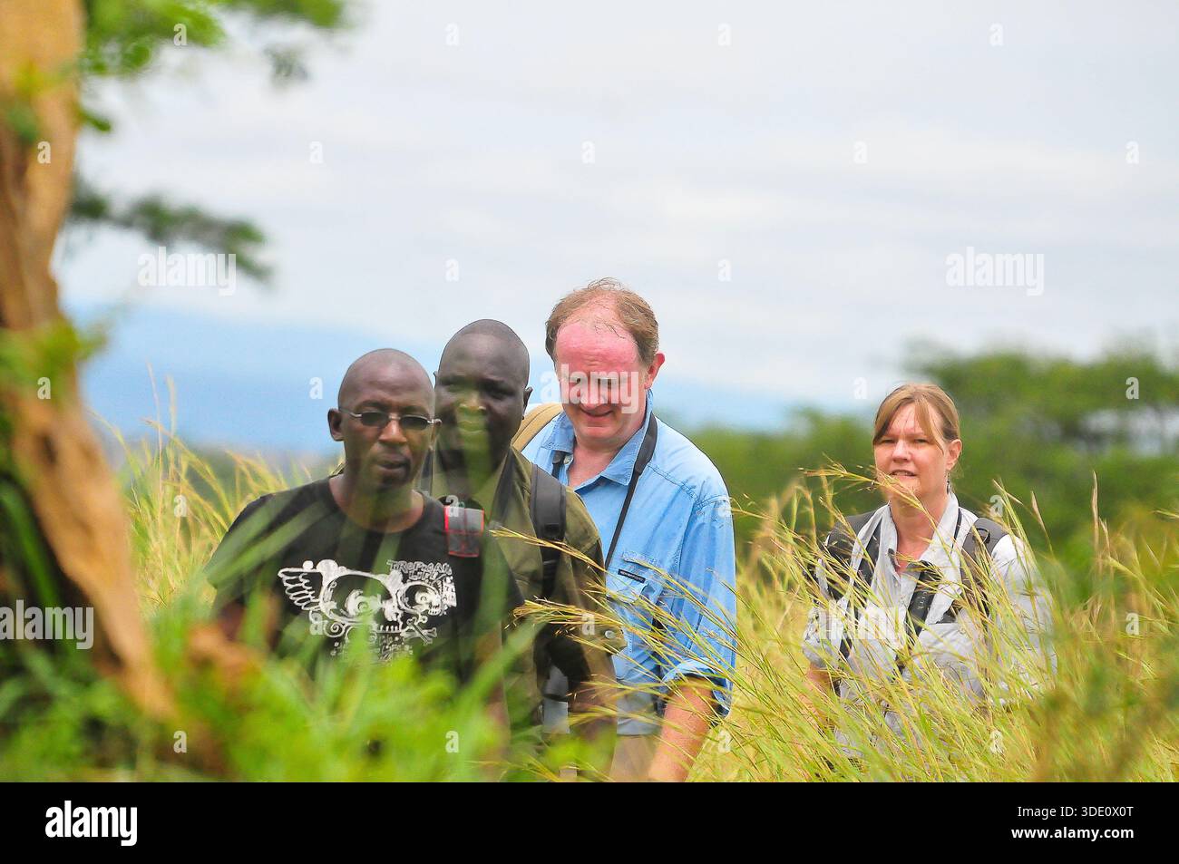 Besucher auf einem Naturspaziergang im Murchison Falls National Park – eingetaucht in die Sehenswürdigkeiten und Klänge der wilden Landschaften Ugandas und erkunden Wanderwege, wo sie sich befinden Stockfoto