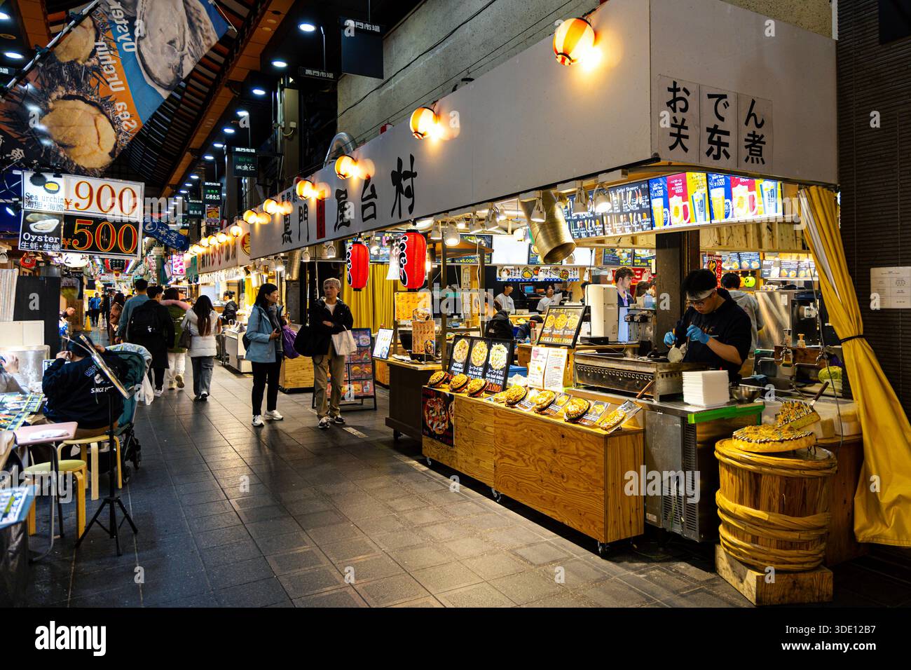 Mann kocht Okonomiyaki an einem Street Food Stall in Kuromon Market, Osaka, Japan Stockfoto