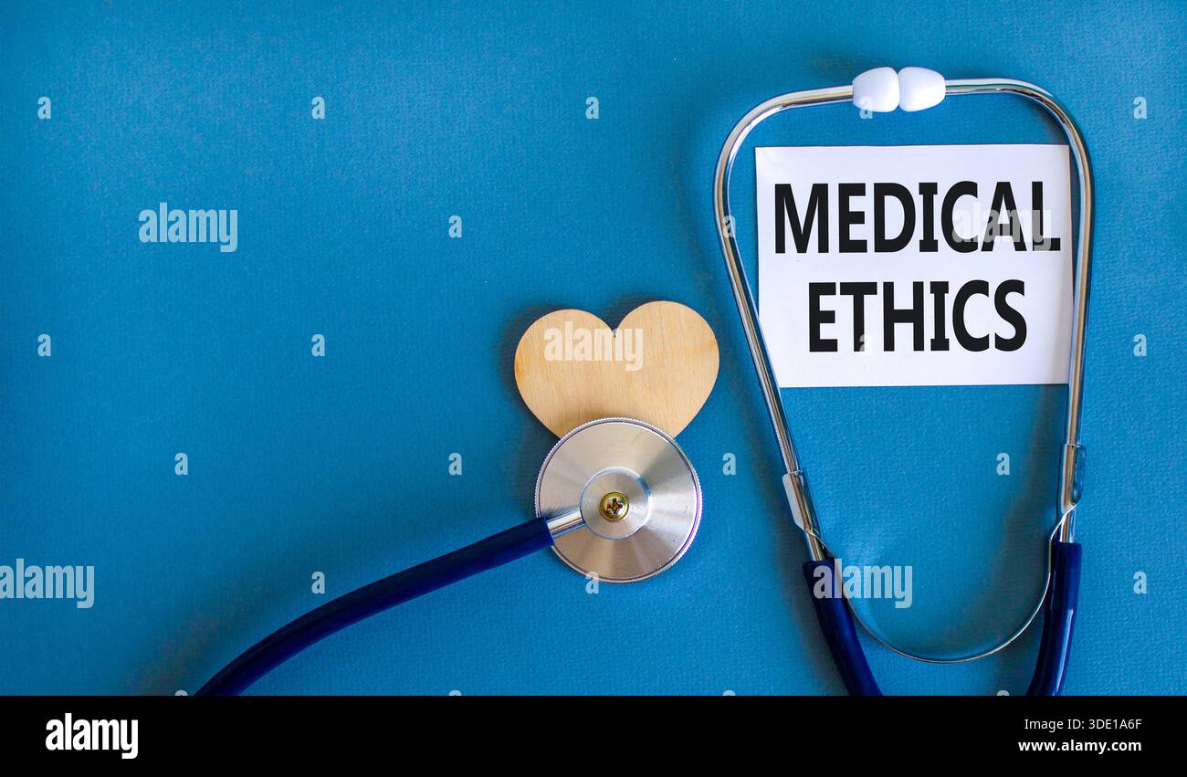 Medizinethik-Symbol. Konzeptworte medizinische Ethik auf der schönen weißen Karte. Holzherz und Stethoskop. Wunderschöner blauer Hintergrund. Medizinisch gesund Stockfoto