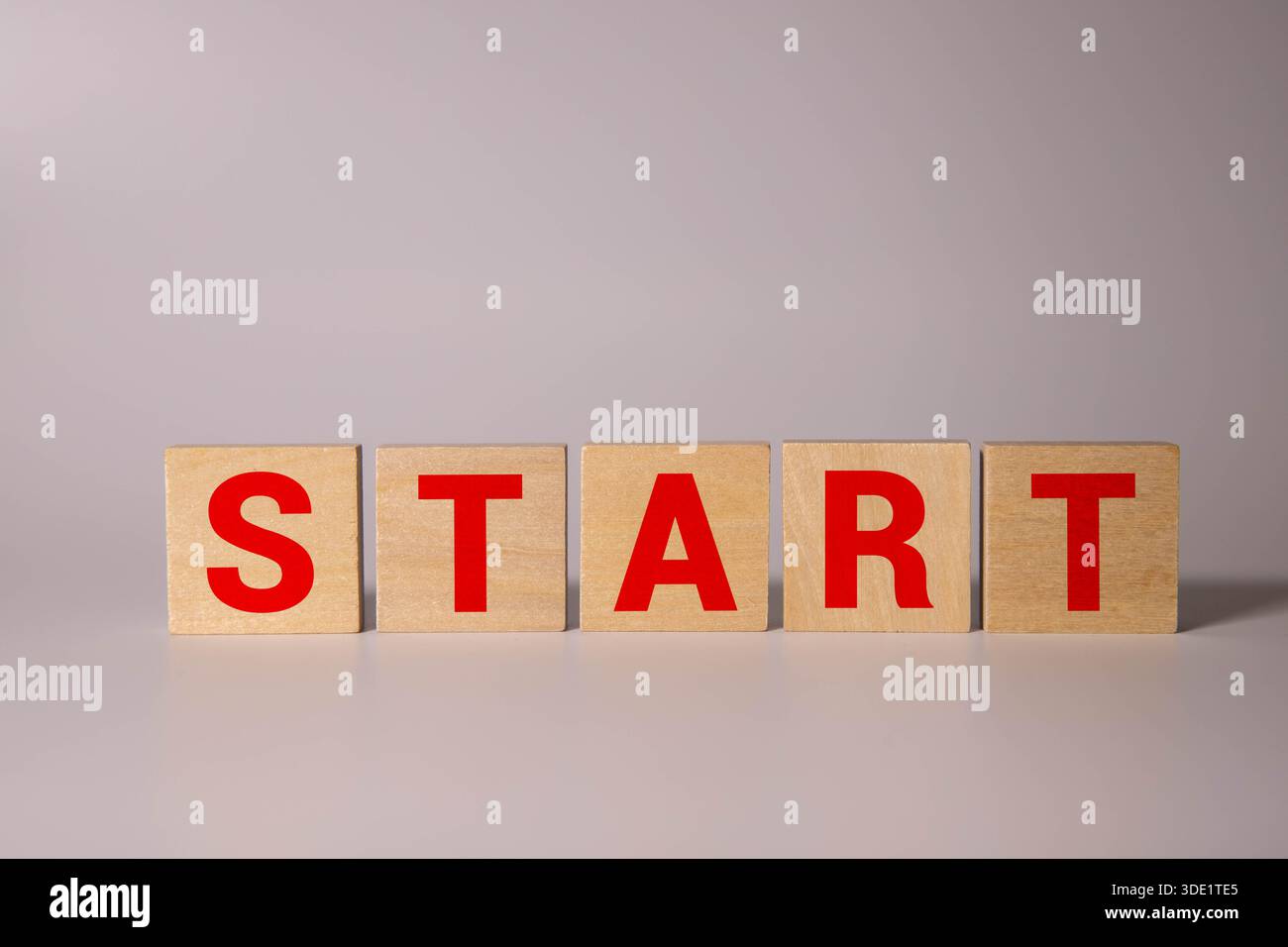 Symbol „hier beginnen“. Holzblöcke mit Wörtern beginnen hier schöner rosa Hintergrund. Business and Start Here Konzept. Kopierbereich. Stockfoto