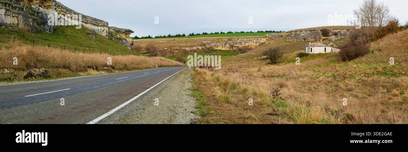 Die Straße in das Tal der Wale in Otago, Neuseeland, benannt nach seinen vielen Meeresfossilien. Auf der rechten Seite befindet sich ein verlassenes Bauernhaus Stockfoto