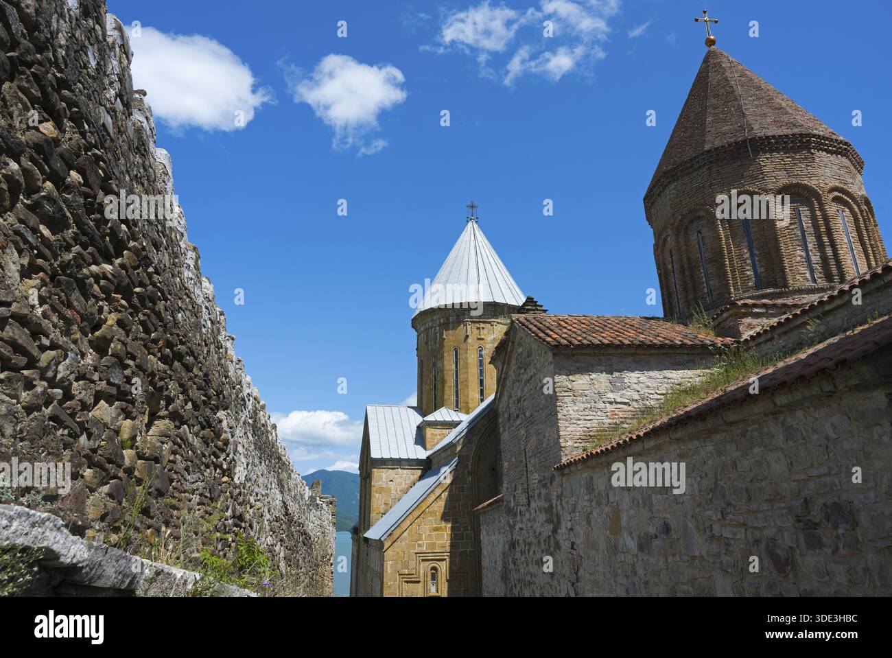 Historischer Klosterkomplex mit Backsteintürmen und einer umliegenden Steinmauer unter blauem Himmel, Schloss Ananuri, Stausee Zhinvali, Jinvali oder Shinvali, M Stockfoto