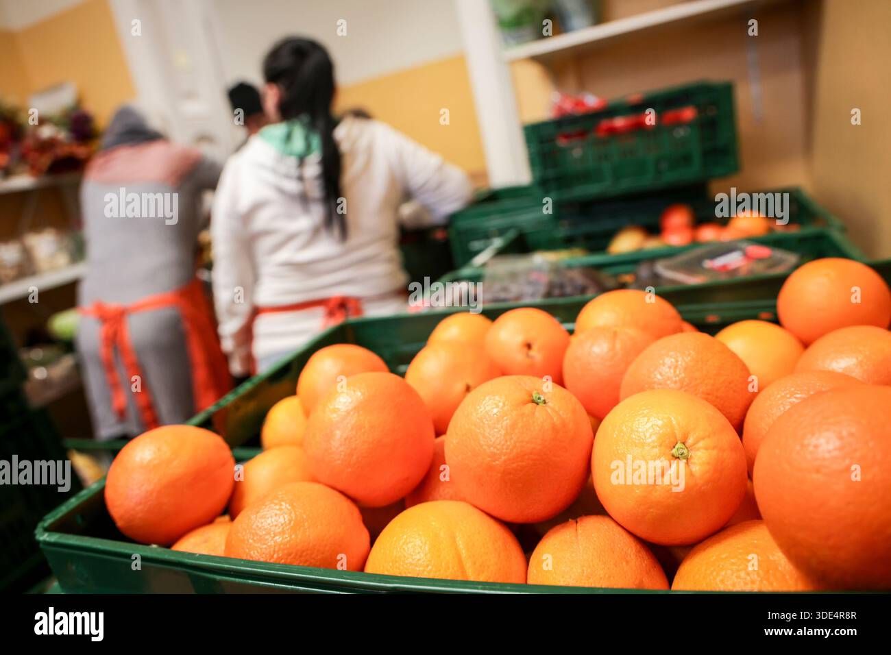 Bremerhaven, Deutschland. Januar 2026. Freiwillige Helfer der Tafel Bremerhaven verteilen Obst und Gemüse an Kunden mit einem neuen Sponsoringverein hat die Bremerhavener Lebensmittelbank ihren Betrieb nach mehrwöchiger Schließung wieder aufgenommen. Rund 1.500 armutsgefährdete Menschen im Bremerhavener Raum können wieder Nahrung von der Tafel beziehen. Quelle: Focke Strangmann/dpa/Alamy Live News Stockfoto