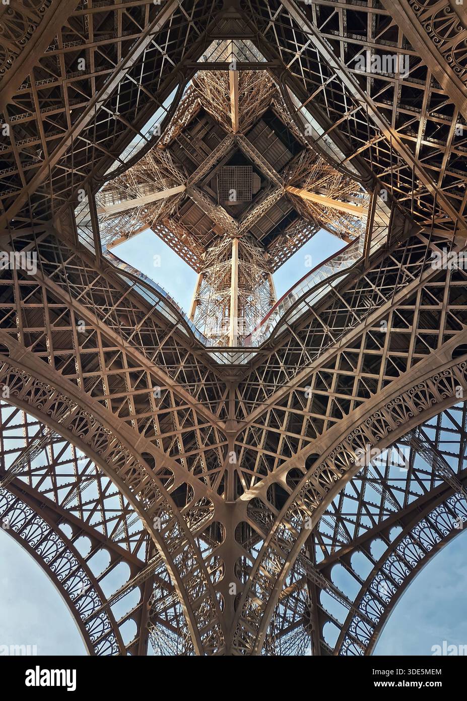 Ein faszinierender Blick in das komplizierte eiserne Herz des Eiffelturms, durch massive Gitterbögen, enthüllt die komplexe geometrische Konstruktion A Stockfoto