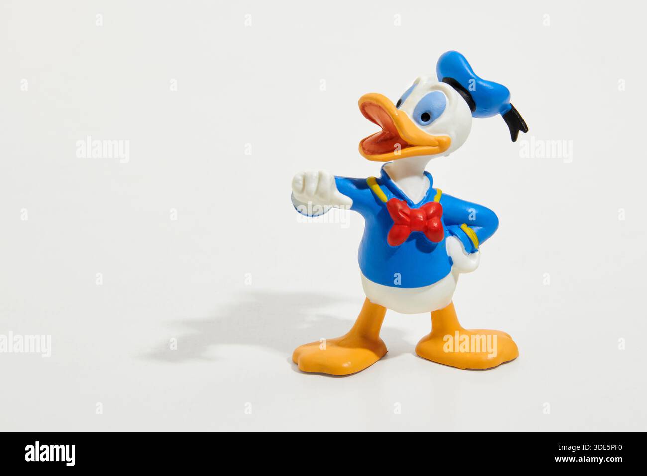 Spielzeugfigur von Donald Duck, der berühmten Walt Disney-Figur auf weißem Hintergrund mit Schatten Stockfoto