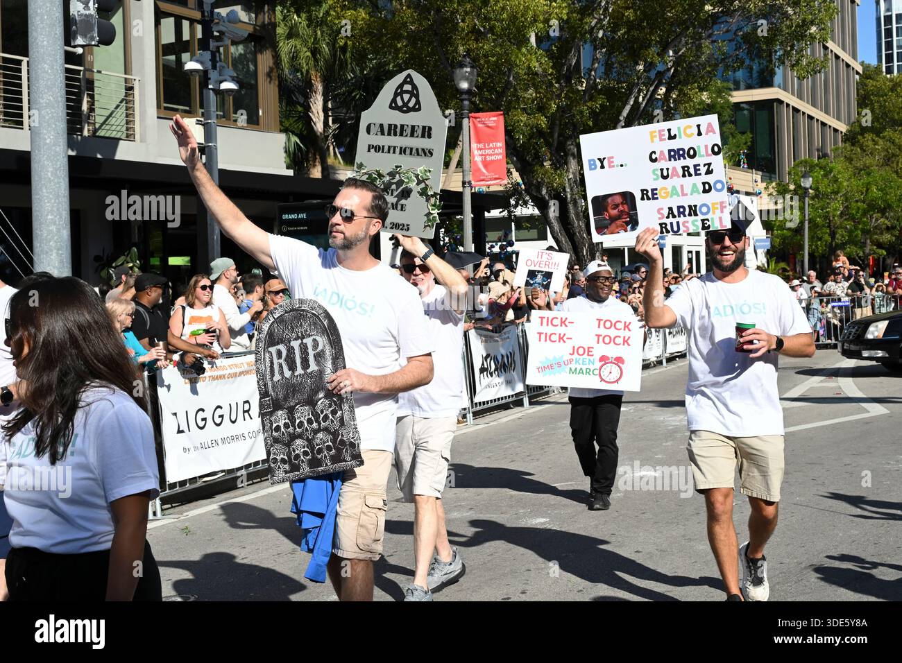 4. Januar 2026, Coconut Grove, Florida, USA: Politische Plakate. Die Teilnehmer marschieren während der 42. Jährlichen King Mango Strut Parade. Die satirische Parade feiert das seltsame, wunderbare und wild unerwartete mit Kostümen, Musik und Community-getriebenen Auftritten am 4. Januar 2026 in Coconut Grove, Florida. (Kreditbild: © Michele Eve Sandberg/ZUMA Press Wire) NUR REDAKTIONELLE VERWENDUNG! Nicht für kommerzielle ZWECKE! Stockfoto