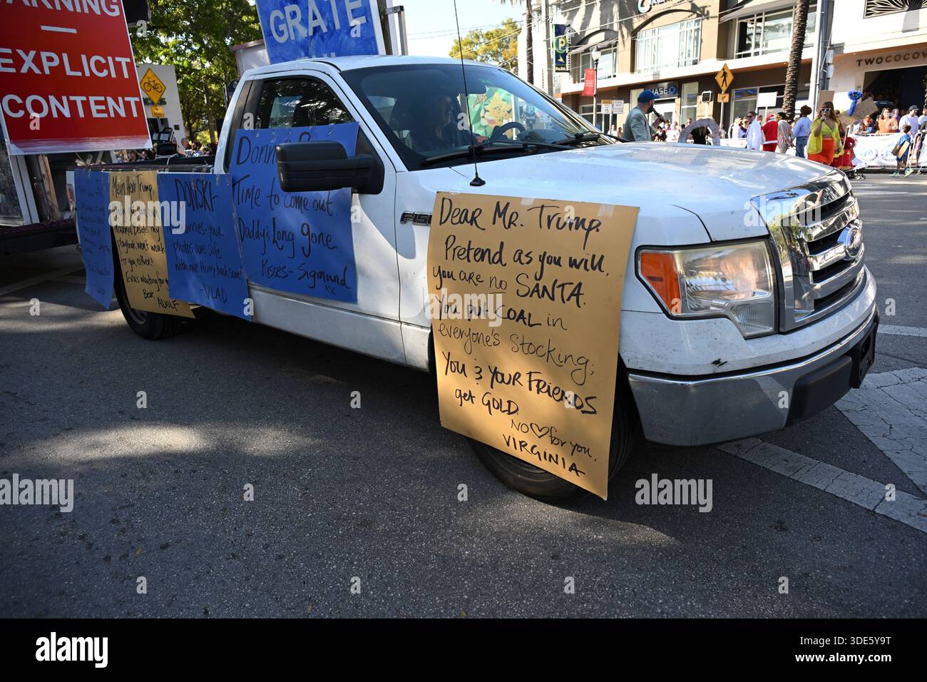 4. Januar 2026, Coconut Grove, Florida, USA: Trump Signage. Die Teilnehmer marschieren während der 42. Jährlichen King Mango Strut Parade. Die satirische Parade feiert das seltsame, wunderbare und wild unerwartete mit Kostümen, Musik und Community-getriebenen Auftritten am 4. Januar 2026 in Coconut Grove, Florida. (Kreditbild: © Michele Eve Sandberg/ZUMA Press Wire) NUR REDAKTIONELLE VERWENDUNG! Nicht für kommerzielle ZWECKE! Stockfoto