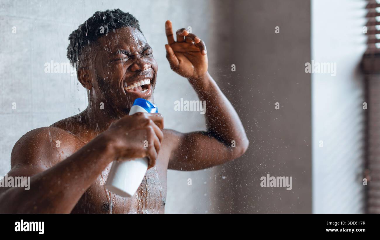 Mann singt während er duscht und den Moment in seinem Badezimmer genießt Stockfoto