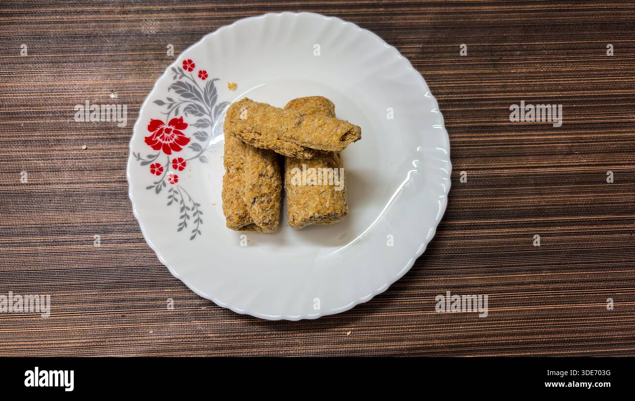 Traditionelle indische Gajak-Süßigkeiten Dessertstangen auf weißem Servierteller Stockfoto