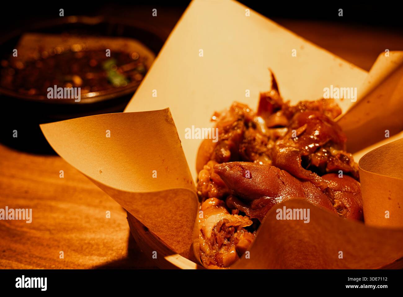 Ein glänzender, geschmorter Schweinesotter liegt auf einem Teller, dessen dunkelbraune Haut mit herzhafter Guizhou Street Food Marinade glänzt. Stockfoto