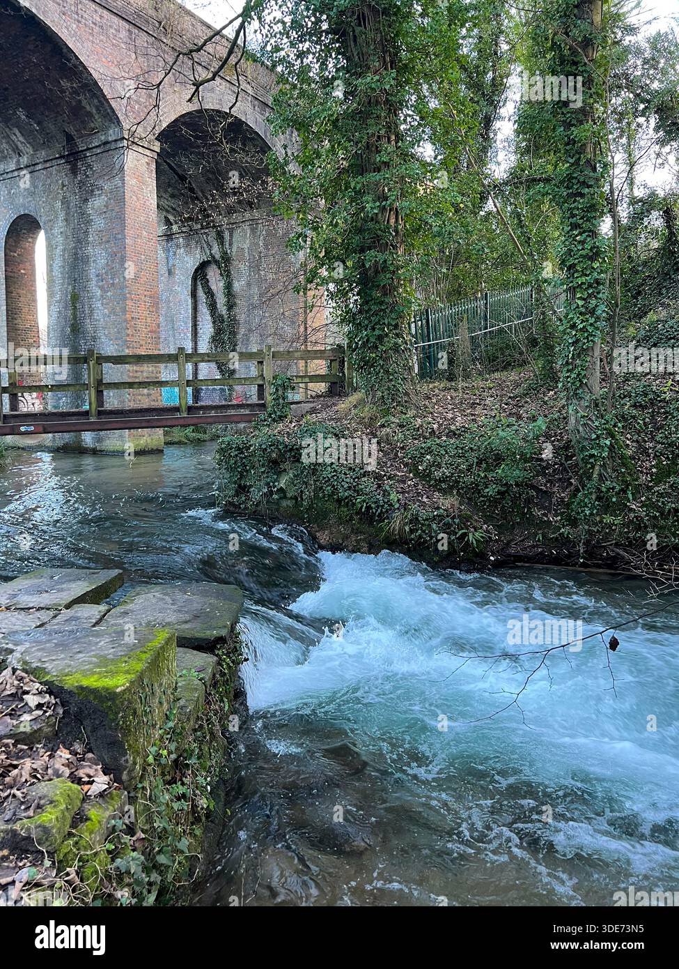 Historisches Backsteinbahnviadukt über den Fluss im üppigen Cotswolds England Stockfoto