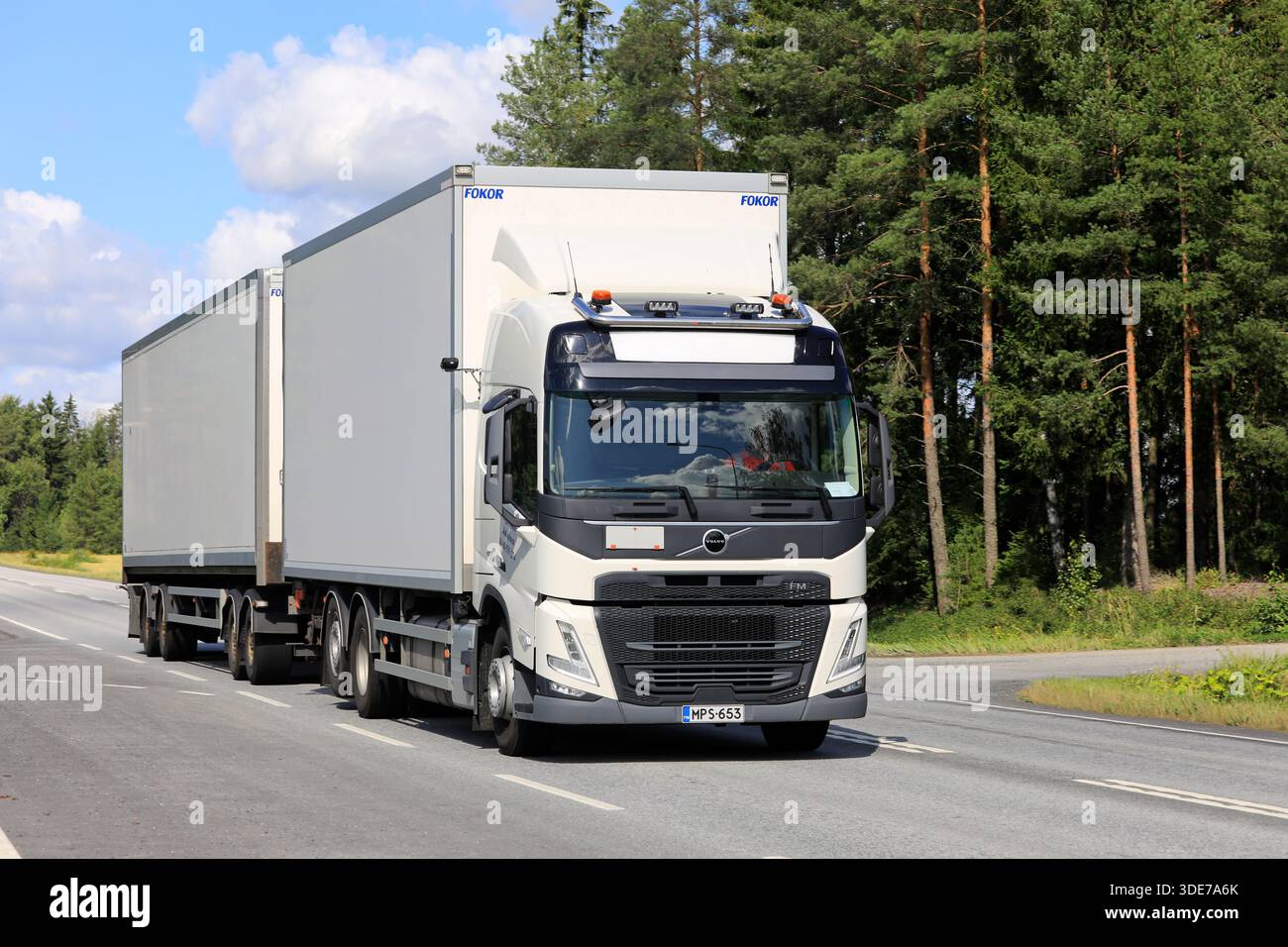 Der neue weiße Lastwagen Volvo FM 6X2 460 zieht an einem sonnigen Sommertag den Anhänger entlang der Autobahn. Jokioinen, Finnland. August 2025. Stockfoto