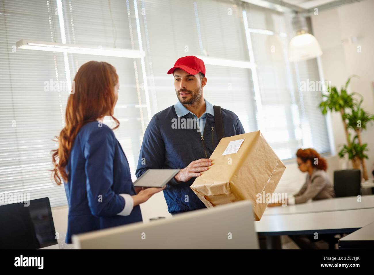 Lieferer, Karton und Versand mit Mitarbeitern im Büro für Lieferanten, Logistik und digitale Signatur. Lieferkette, Online-Shopping und -Paket Stockfoto
