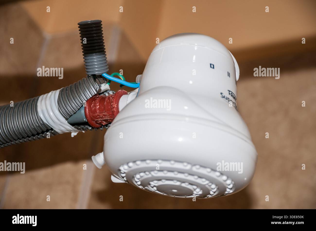 Lose, freiliegende Drähte in einer Wasserheizung in der Dusche, Duschkopf, Dusche, alt, ausgefranst, gestreift, schmutzig, skurril, jankig Stockfoto