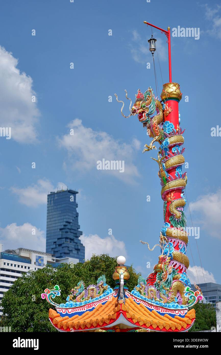Die Drachensäule steht vor dem blauen Himmel und dem King Power Mahanakhon Pixel Tower in Bangkok und zeigt die lebendige Kultur der Stadt. Stockfoto