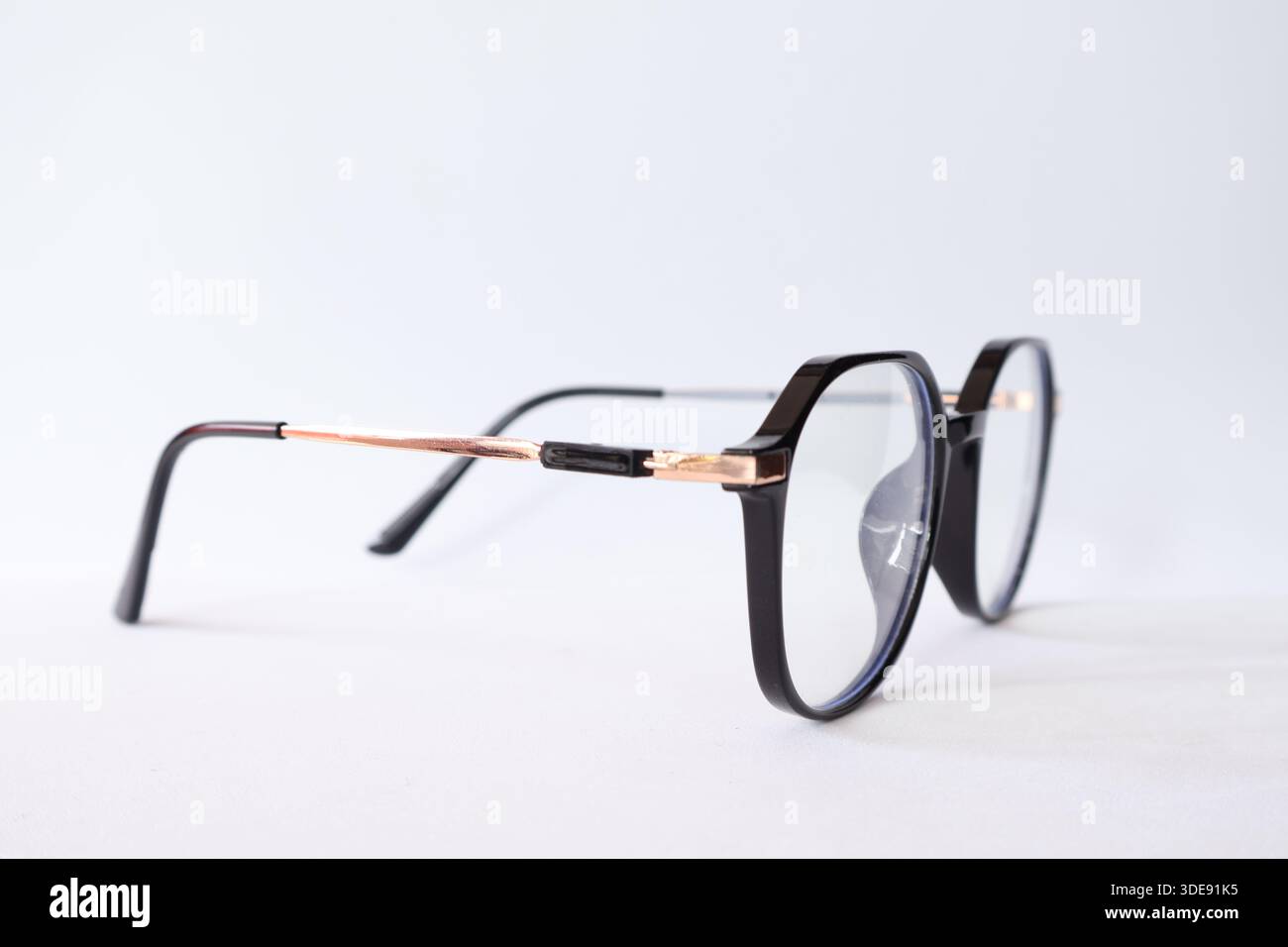 Moderne Brille mit schwarzem Rahmen und Roségold-Details, isoliert auf weißem Hintergrund. Minimalistisches Mode- und Vision-Konzept. Stockfoto