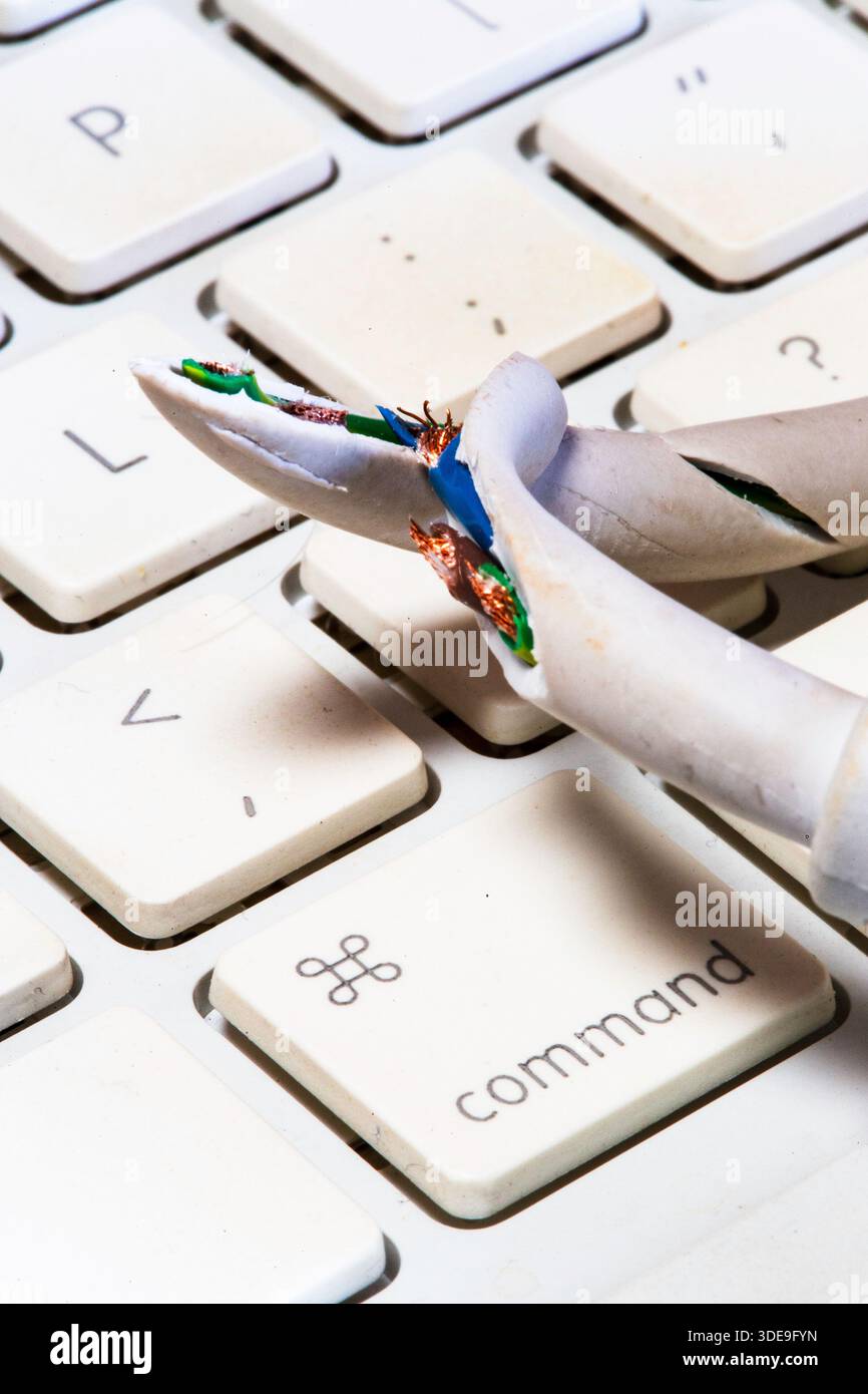 Stillleben eines ausgefransten Computerkabels an einer Laptop-Tastatur, 2026, USA Stockfoto