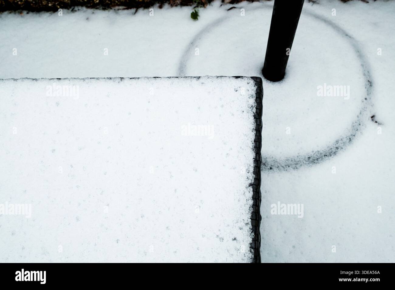 Abstrakte Muster im Schnee auf Gartenmöbeln Stockfoto