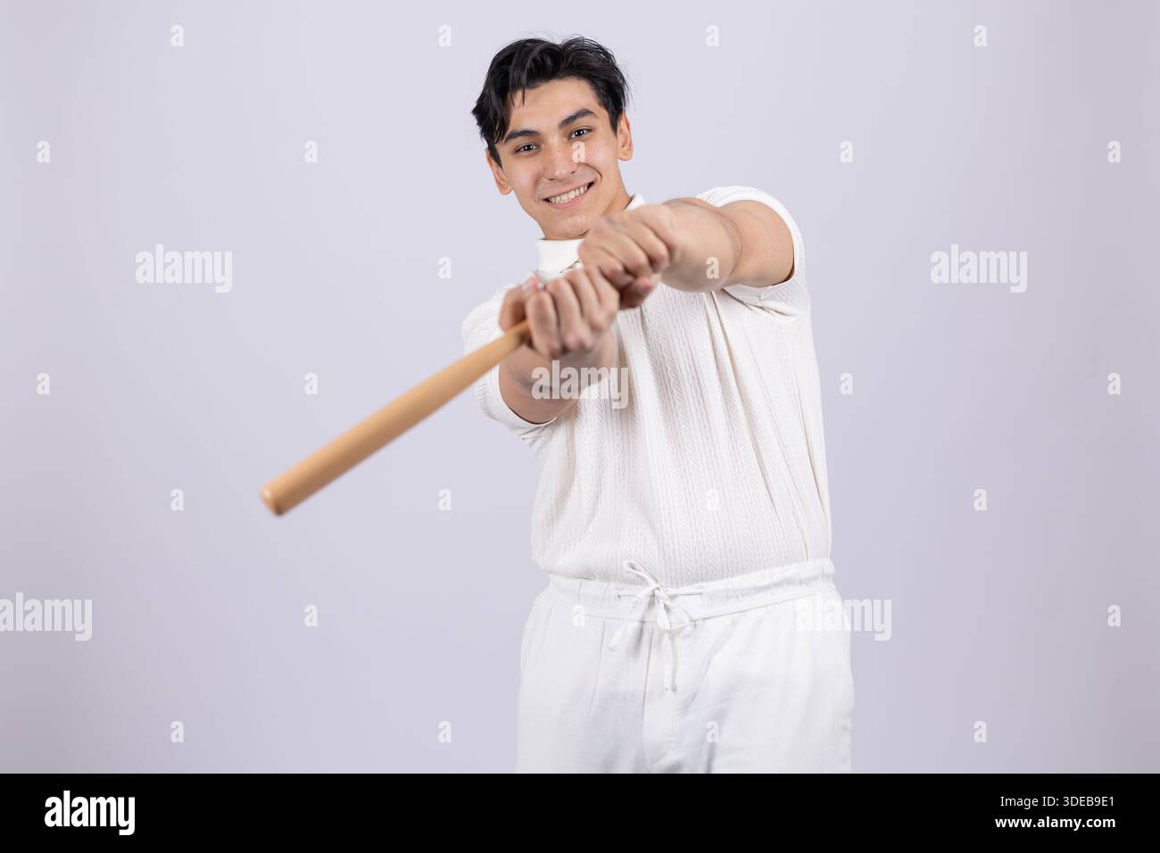 Ein Mann, der einen Holzstock in einer Baseballposition hält. Stockfoto