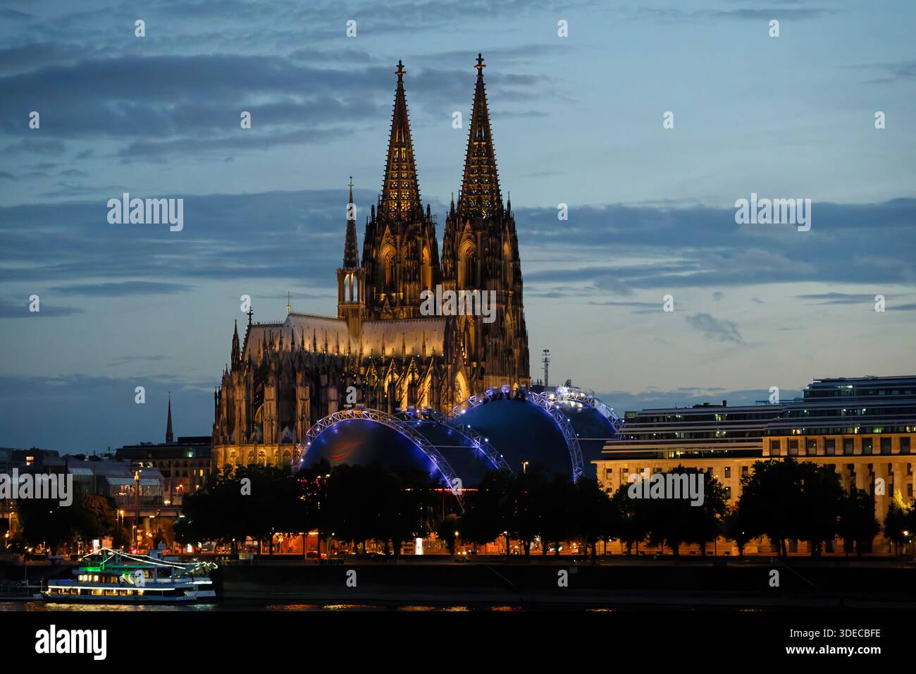 Nachtansicht auf den Kölner Dom, den blau beleuchteten Musical Dome und das EASA-Gebäude am Rheinufer in Deutschland bei Dämmerung Stockfoto