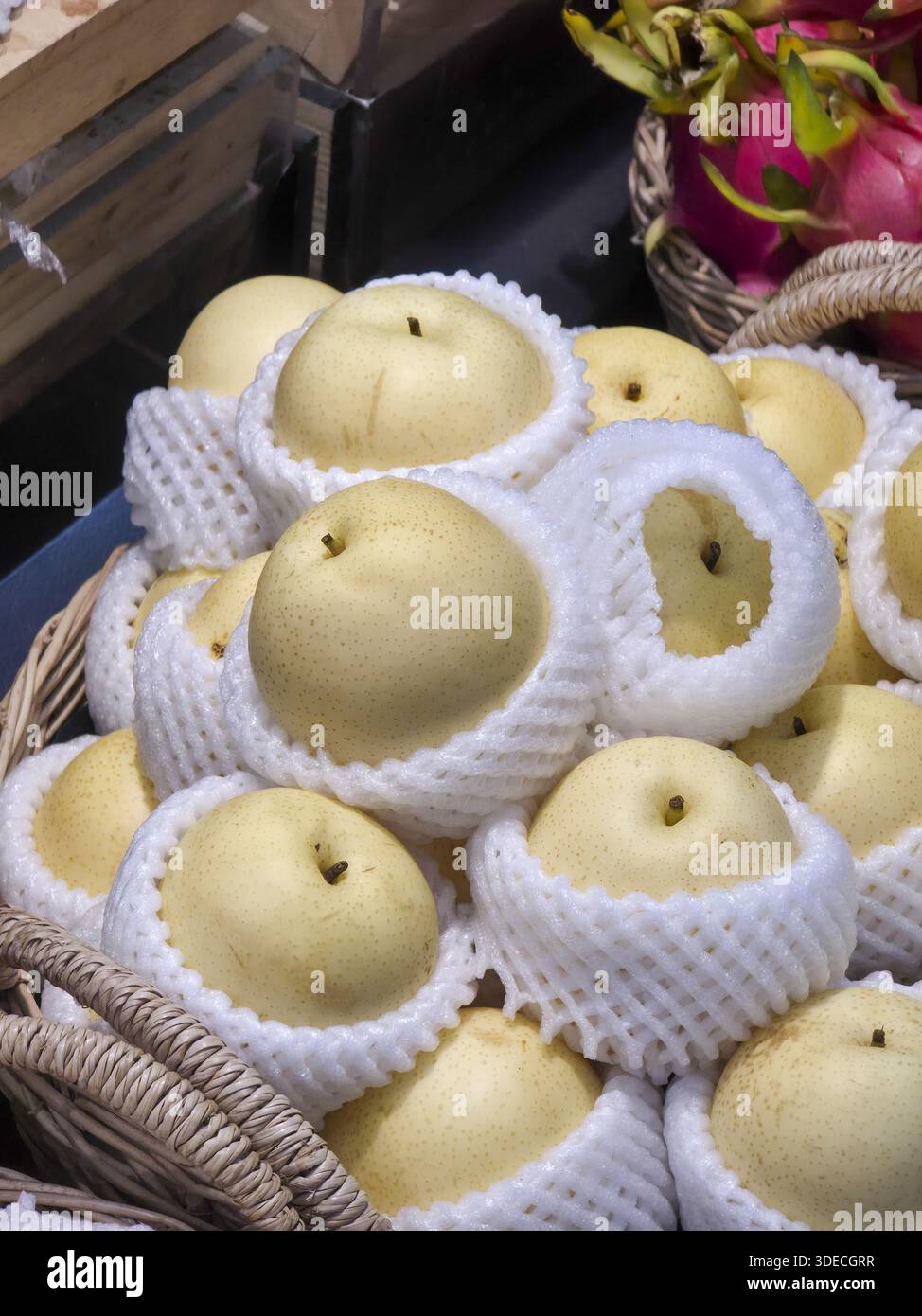 Frischer Bio asiatischer Birnenstapel mit schützendem weißem Schaum Netz Korb Regal Supermarkt Lebensmittelgeschäft mit gesundem süßen saftigen Obstmarkt Stockfoto