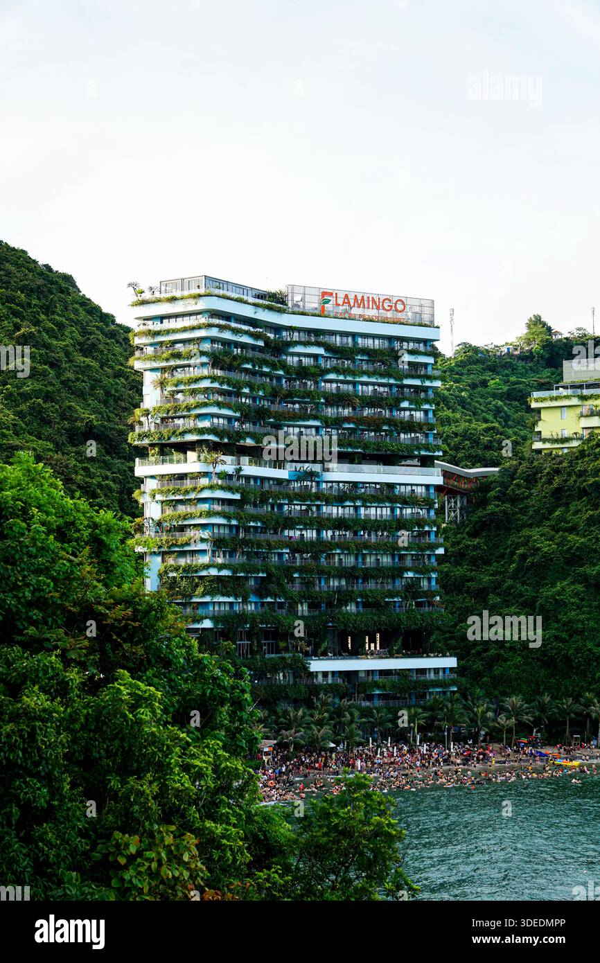 Flamingo Cat Ba Resort mit grünen, vertikalen Gärten auf einem Hügel mit Blick auf einen belebten Strand in Hai Phong, Vietnam. Stockfoto