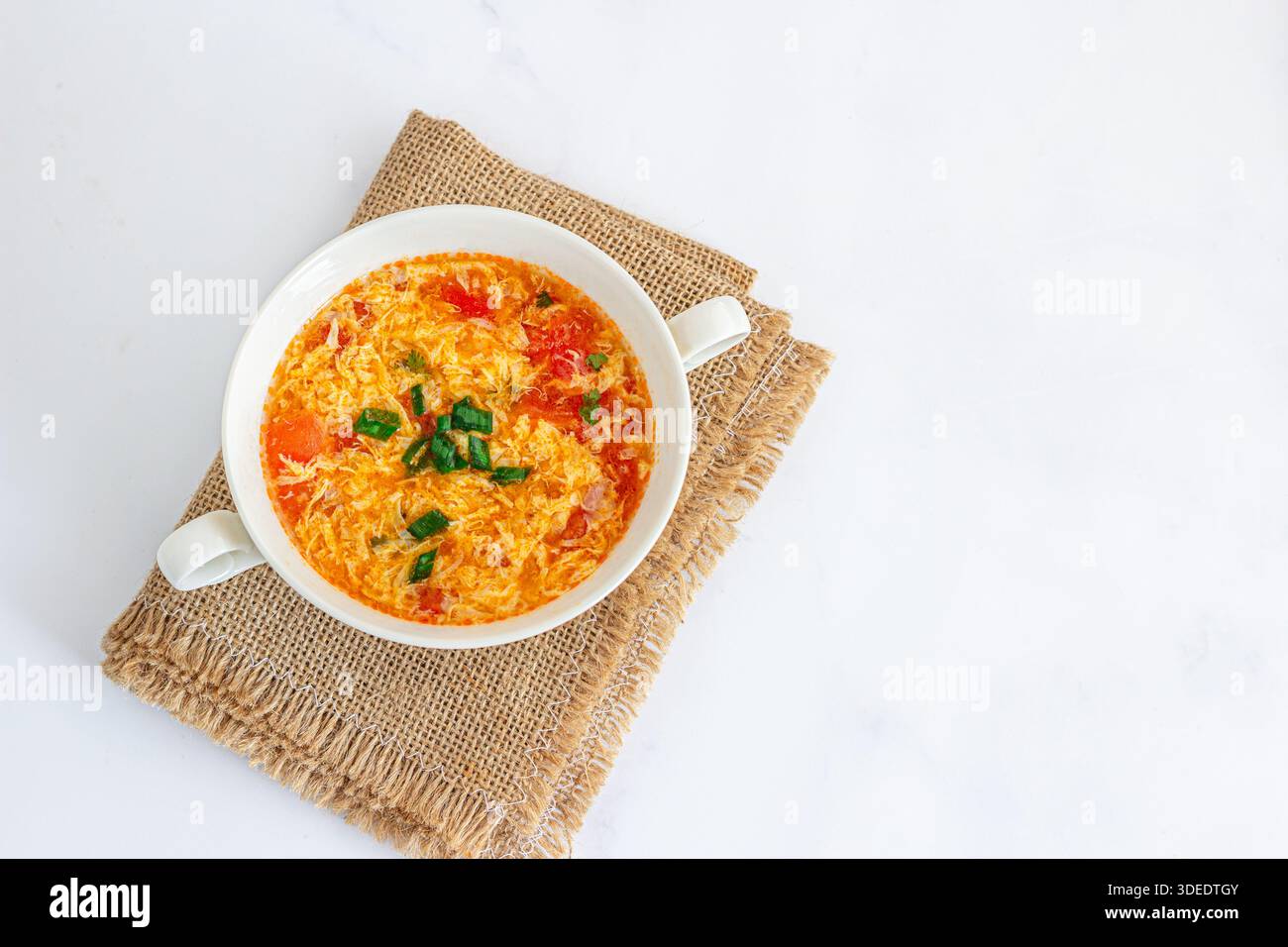 Hausgemachte Tomaten-Ei-Drop-Suppe in Bowl, traditionelles chinesisches Komfortessen Stockfoto