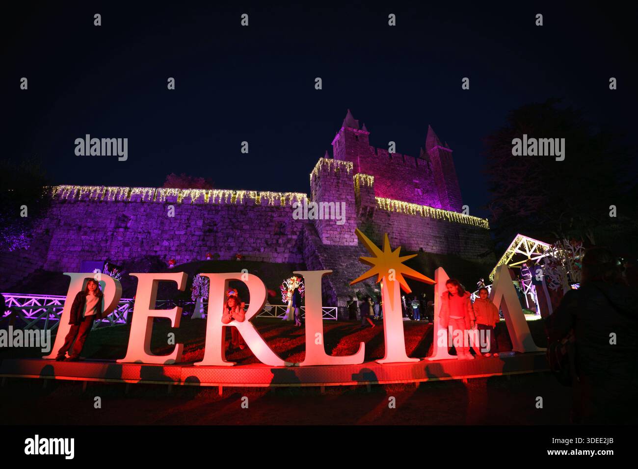 Nächtlicher Blick auf das Schloss Santa Maria da Feira, beleuchtet mit bunten Lichtern während der Perlim Christmas Themenpark Veranstaltung Stockfoto