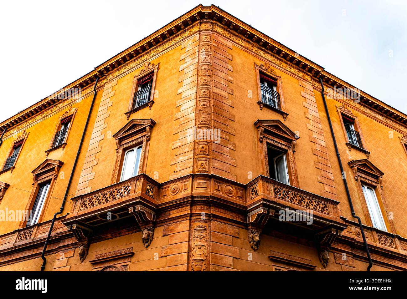 Aus nächster Nähe ein historisches oranges Gebäude mit kunstvollen architektonischen Details, Balkonen und Fenstern Stockfoto