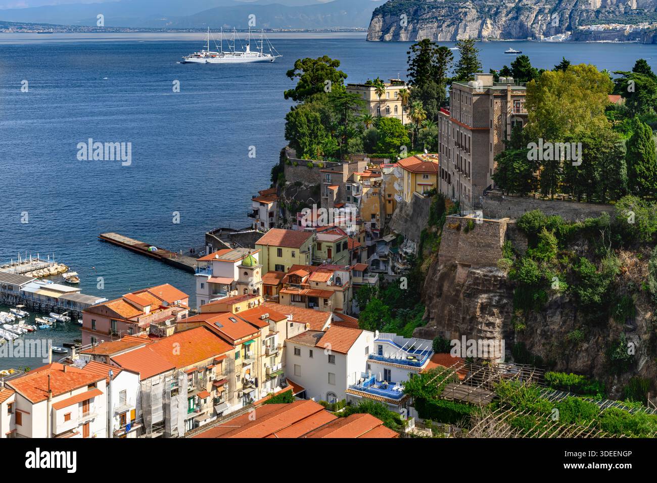 Blick hinunter auf die Küste von Sorrent. Der Strand ist gesäumt von Touristen, Restaurants und farbenfrohen Häusern sowie Booten und Yachten am Yachthafen Via del Mare. Stockfoto