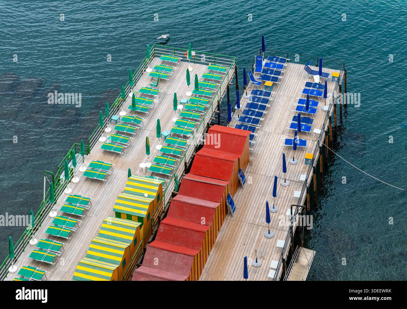 Blick hinunter auf den privaten Bereich von Sorrent am Meer Bagni Salvatore. Mit Touristen, Liegestühlen, Sonnenschirmen, Badehütten, Ruderbooten und Kajaks. Stockfoto