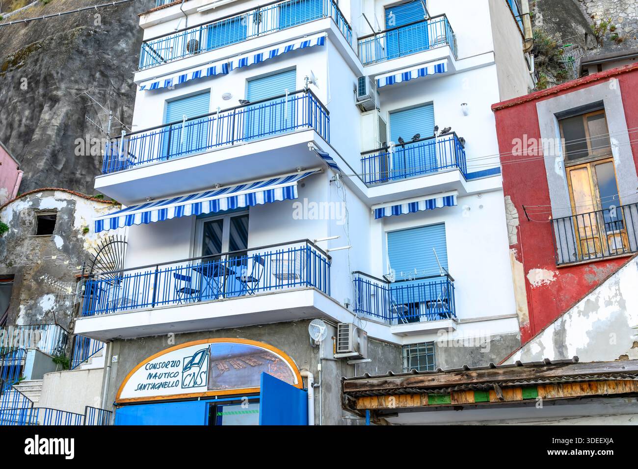 Häuser am Meer, Wohnungen und Lets Klammern sich an den Klippen von Sorrento Piano der Yachthafen gegenüber wird von Fischern und Fähren zur Amalfiküste genutzt. Stockfoto