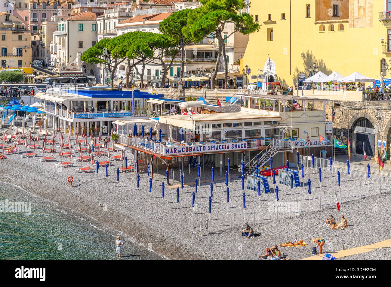 Blick auf Amalfis Privatstrand lido Mar Di Cobalto, Italien. Umgeben von farbenfrohen, bildschönen Häusern und Restaurants, Yachten und Yachthafen. Stockfoto