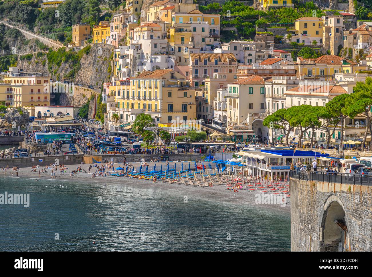 Blick auf Amalfis Privatstrand lido Mar Di Cobalto, Italien. Umgeben von farbenfrohen, bildschönen Häusern und Restaurants, Yachten und Yachthafen. Stockfoto