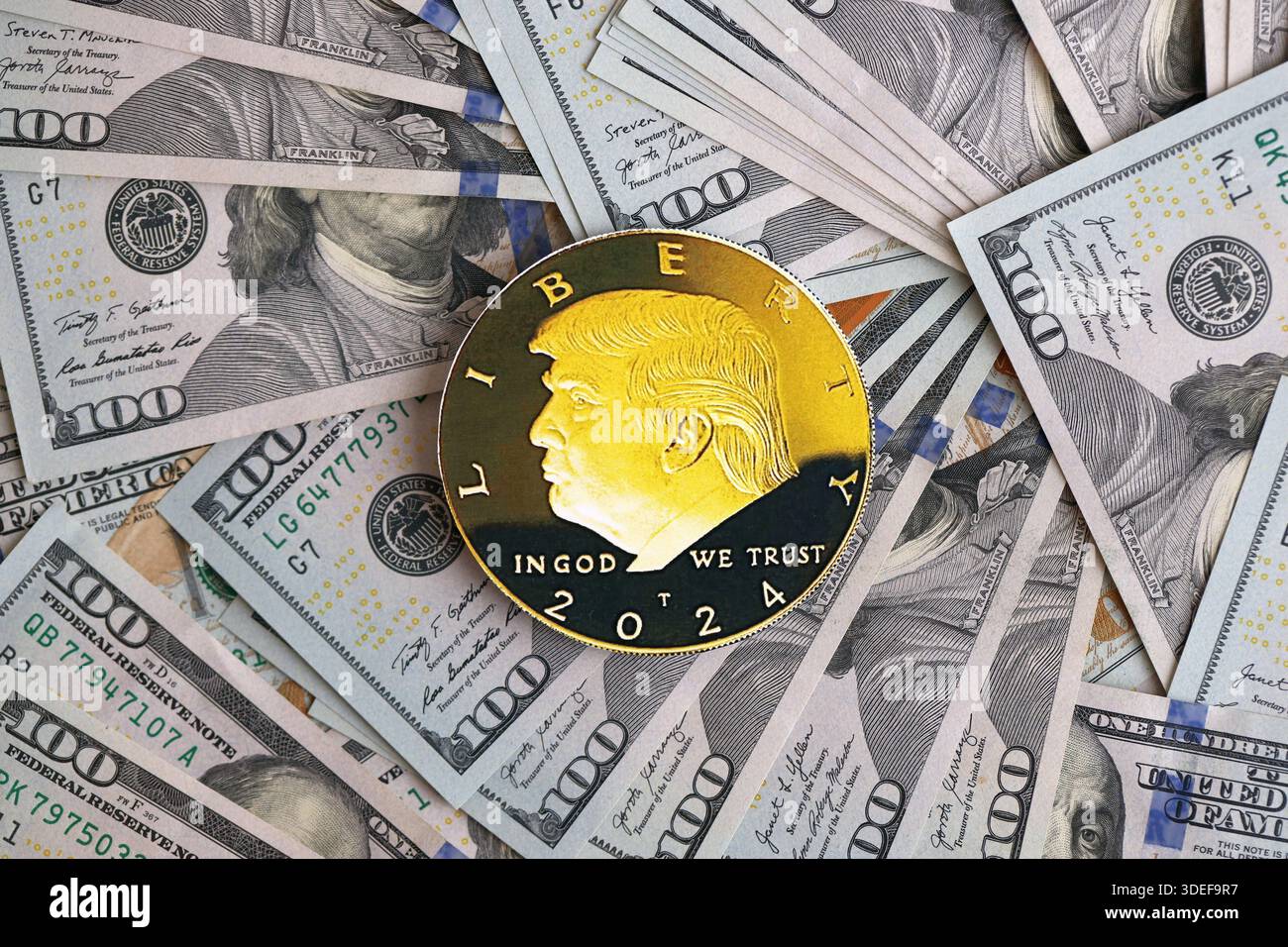 KIEW, UKRAINE - 13. DEZEMBER 2025 Trump Goldmünze auf großen Mengen von US-Dollar-Banknoten Stockfoto