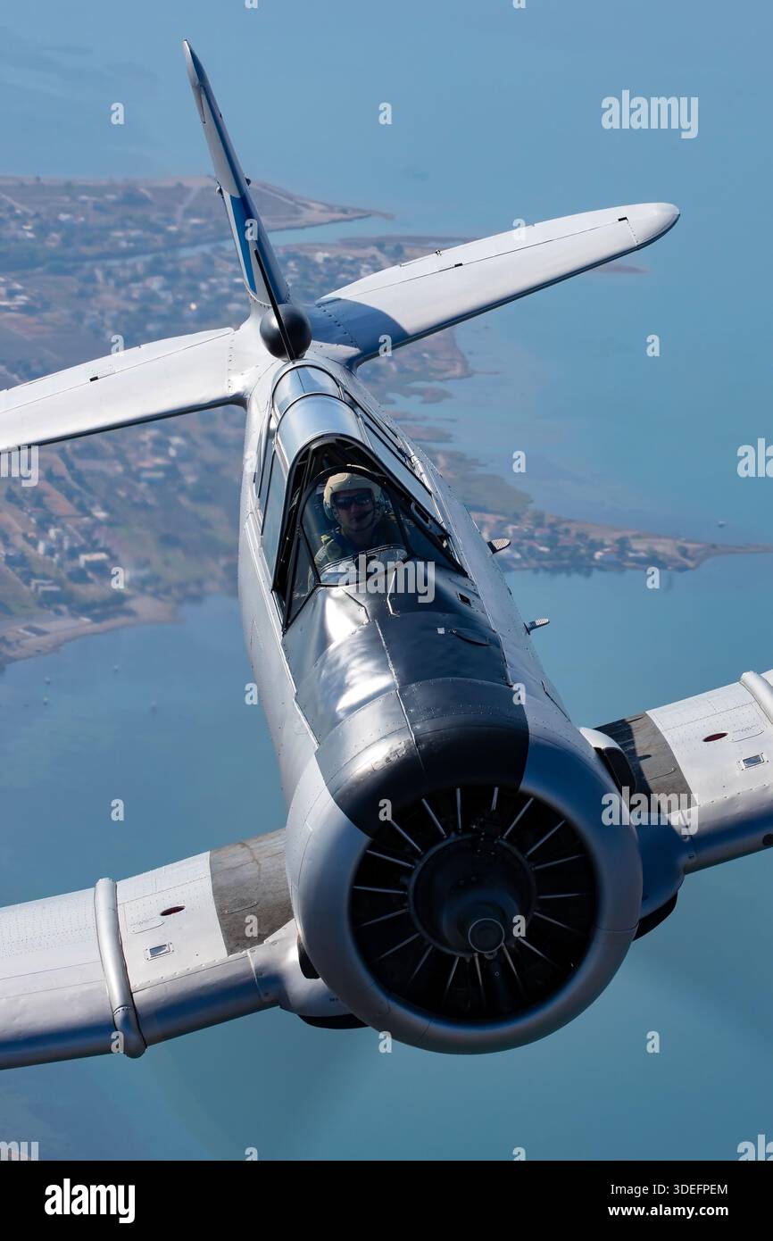 Ein nordamerikanischer T-6G Texan der griechischen Luftwaffe, Kennzeichen 49-3424, Serie 168-548, wird in Nahaufnahme während der Luft-Luft-Fotografie auf der Athens Flying Week 2025 gezeigt. Dieser einmotorige, tief sitzende Fortgeschrittene Trainer verwendet einen Pratt & Whitney R-1340 Radialkolbenmotor und ein Tandemcockpit mit Schutzdach. Das Bild zeigt den Piloten, den Rumpf, die Flügel, das Heck und den Propeller. Hervorhebung der historischen Rolle des Luftfahrzeugs bei der Ausbildung und bei der Demonstration der betrieblichen Befähigung. Stockfoto