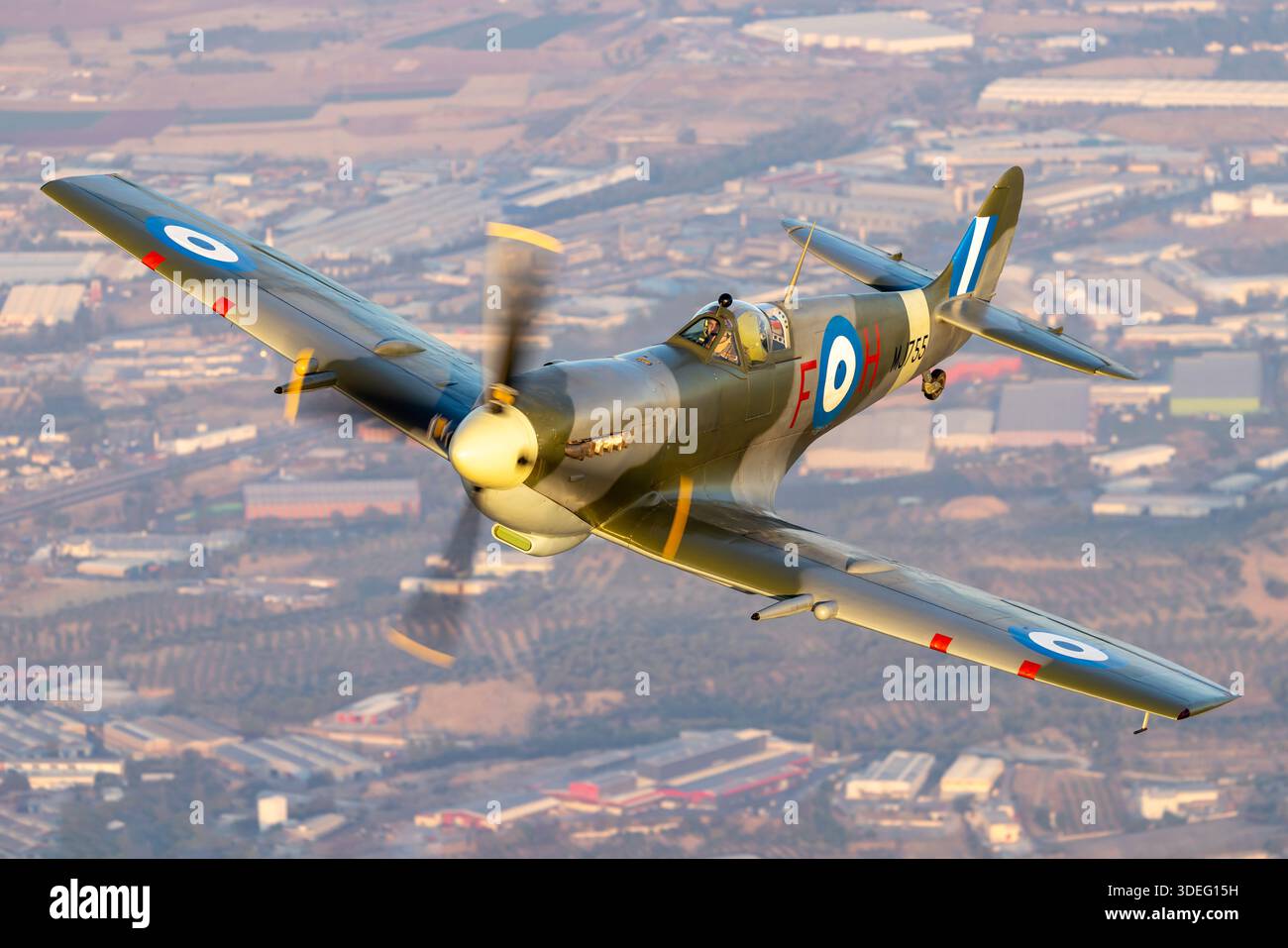 Luft-Luft-Foto, das den Supermarine Spitfire MK IX MJ755 während des Fluges während der Athens Flying Week 2025 einfängt. Das einsitzige Kampfflugzeug verfügt über einen flüssigkeitsgekühlten Rolls-Royce Merlin 61 V12-Motor und ist mit einem niedrigen Monoplane-Design mit elliptischen Flügeln ausgestattet. Das Bild zeigt das Nasenprofil des Flugzeugs, den Propeller, die Auspuffkammern und die Heckbaugruppe. Das Flugzeug zeigt die Hellenic Air Force Markierungen und demonstriert kontrollierten Flug in einer öffentlichen Flugumgebung. Stockfoto