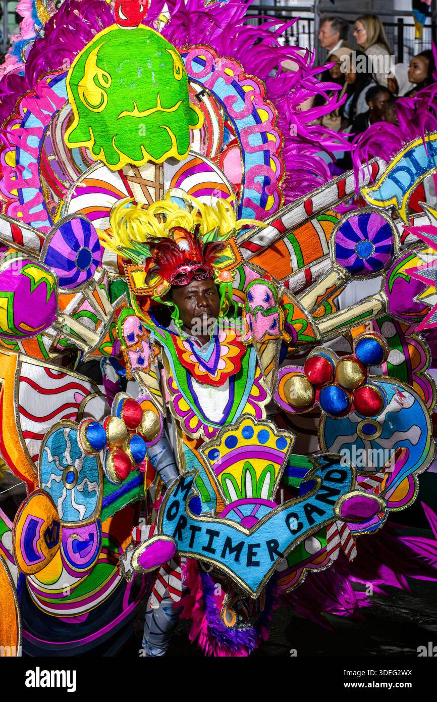 Nassau, Bahamas - 01. Januar 2026: Blick auf einen pulsierenden Junkanoo-Künstler inmitten einer atemberaubenden Explosion aus Fuchsia, Limette und Kobalt, verziert mit Intrika Stockfoto