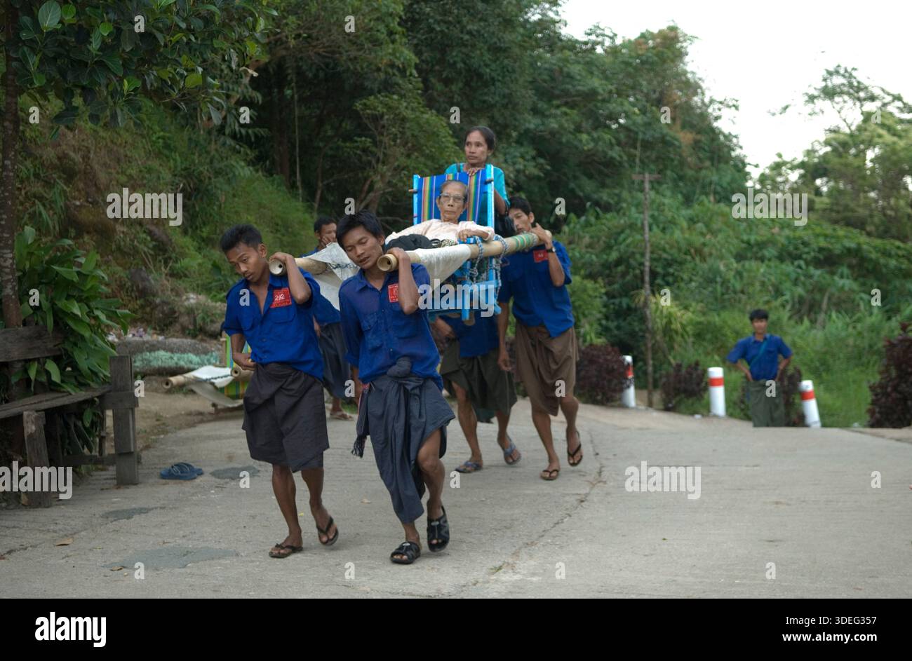 Träger tragen eine ältere Frau den Berg hinauf zum Golden Rock Tazaungdaing Festival auf einer traditionellen Bambustrage, die manchmal als hölzernes Streichbett oder einfach nur als Trage bezeichnet wird, Myanmars Festival of Lights. Ein buddhistisches fest am Ende der Regenzeit, wo der heilige Goldene Felsen zu einem wichtigen Wallfahrtsort wird. Kyaiktiyo, Mons State, Myanmar 9. November 2011 2010, HOMER SYKES. Stockfoto