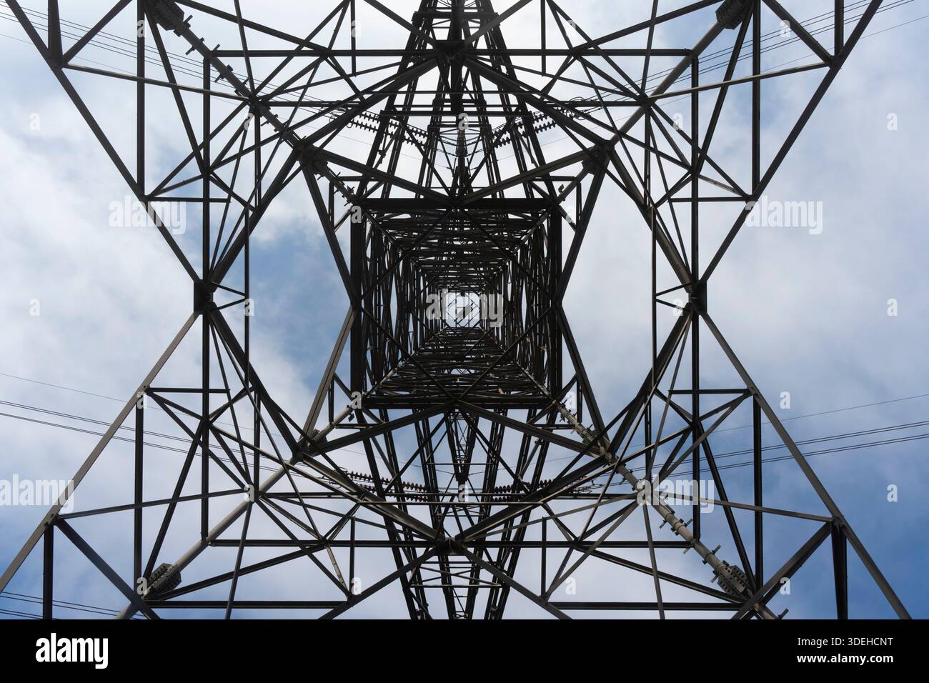 Ich schaue auf einen Energiepylon und übermittle Elektrizität durch die Landschaft. Stockfoto