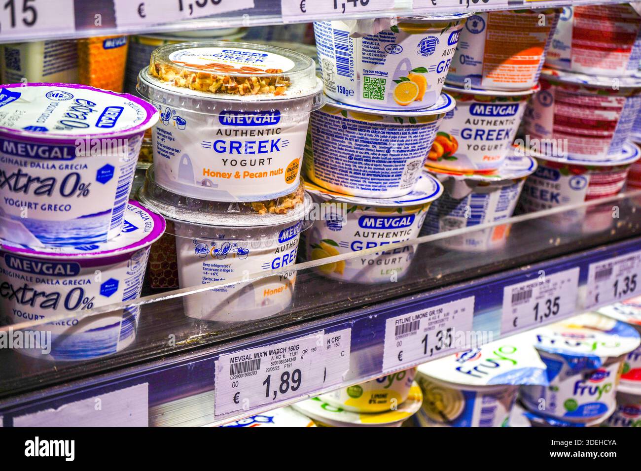 Eine große Auswahl griechischer Joghurtprodukte in Kühlregalen in einem italienischen Supermarkt von Carrefour, in dem moderne Lebensmittelverpackungen im Einzelhandel präsentiert werden. Stockfoto