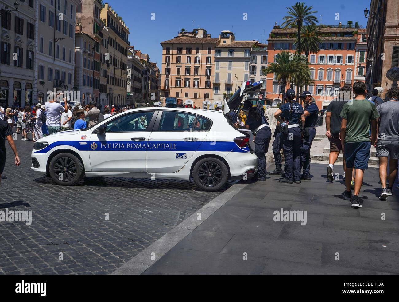 Ein Streifenwagen der „Polizia Roma Capitale“ parkte auf der belebten Piazza di Spagna mit Beamten, die an einem geschäftigen Nachmittag am offenen Kofferraum standen. Stockfoto