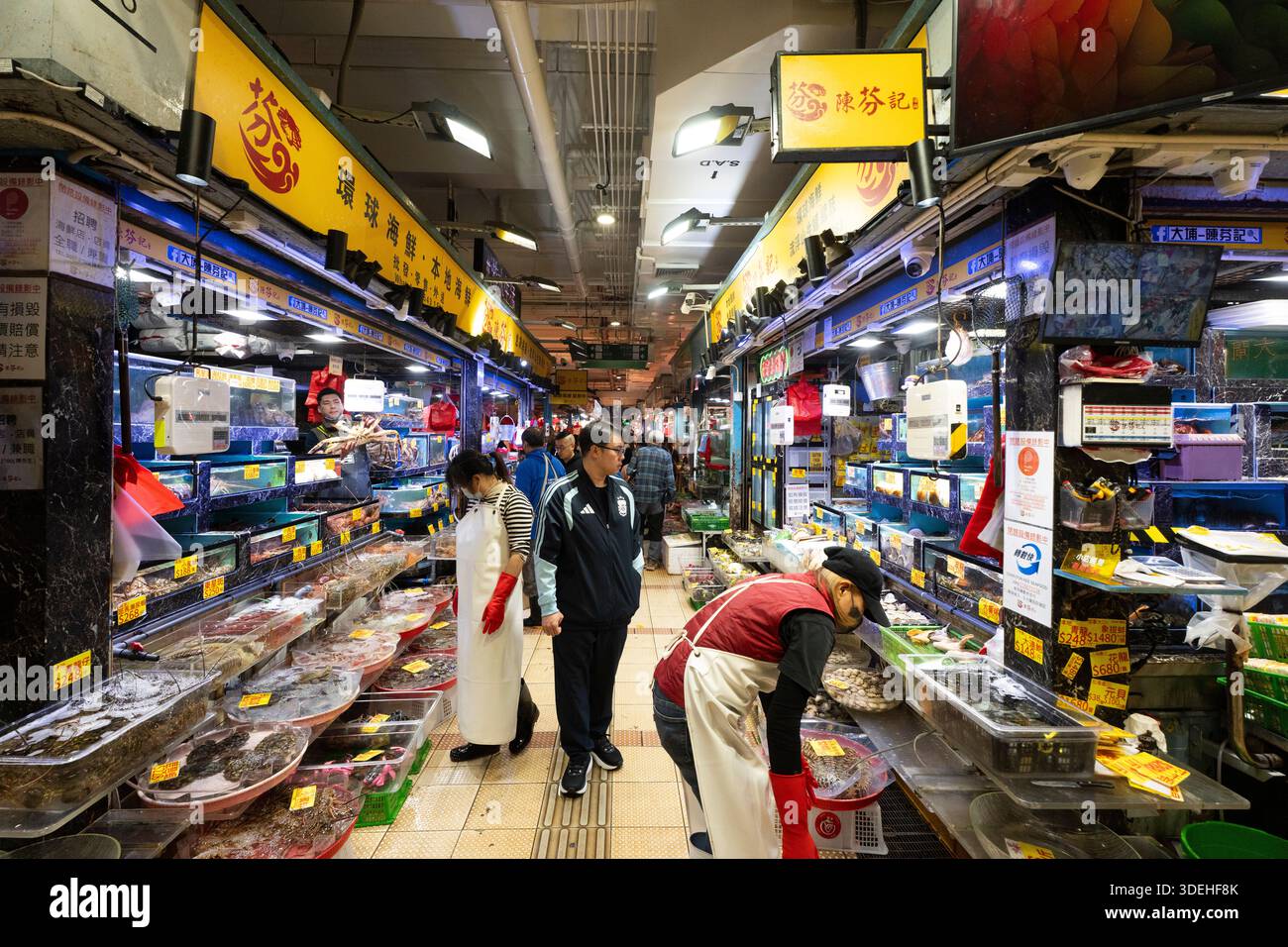 Fischmarktverkäufer auf dem Tai Po Wet Market, Hongkong, verkaufen frische Meeresfrüchte an Kunden. Stockfoto