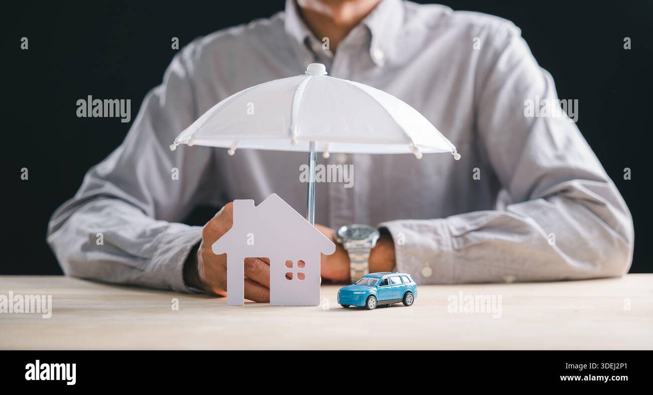 Geschäftsmann präsentiert Home Car Versicherung Konzept, bietet Haus und Auto Abdeckung für Familie Leben Gesundheit Geschäft Vermögenswerte, Schirm bietet Sicherheit A Stockfoto